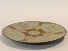 An Dutch Indonesian engraved bronze plate with engraved stylised floral design and central medallion