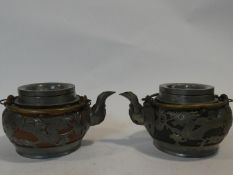 Two Chinese vintage Yixing pottery tea pots with pewter dragon pierced overlays. One with black