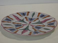 An antique hand painted stylised flower and butterfly design plate. 21x21cm