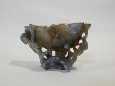 A Chinese carved agate libation cup, with lotus flowers and a female figure in traditional robe H.