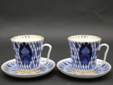 A pair of Russian blue and white cups and saucers with gilt highlights, marked Imperial Porcelain to