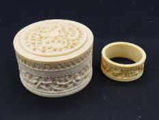 An antique Chinese carved and pierced screw lidded ivory box with dragons along with a carved