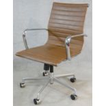 A Charles Eames style swivel office armchair with rise and fall action in light tan leather
