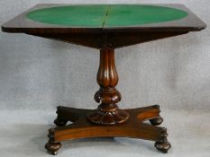A mid Victorian mahogany foldover top card table raised on shaped reeded pedestal on quattreform