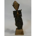 An Oriental brass coin Buddha sculpture with carved wooden head and hands, mounted on carved