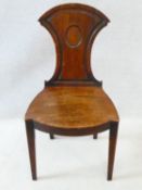 A Regency mahogany hall chair with shield back and central roundel above panel seat on square