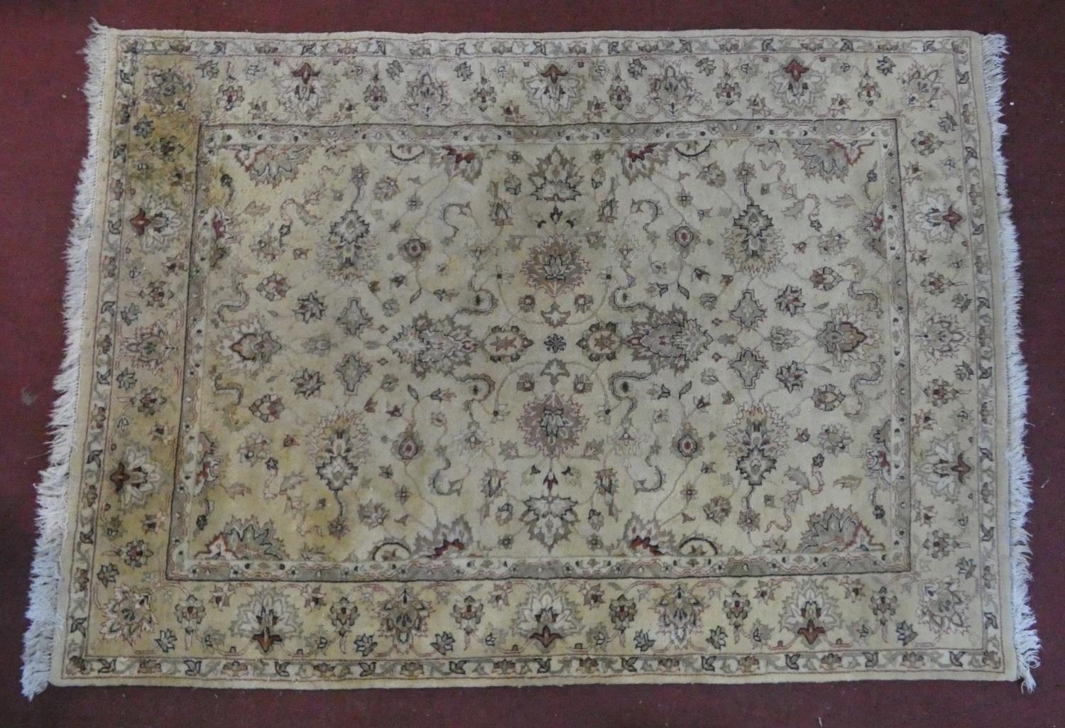 A Persian style rug with all over naturalistic scrolling floral decoration on a cream ground