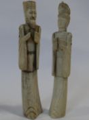 A pair of carved and stained Chinese bone figures of immortals. H.25cm