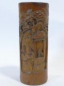 A Chinese carved bamboo brush pot with a village scene and trees. H.26cm