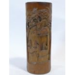 A Chinese carved bamboo brush pot with a village scene and trees. H.26cm