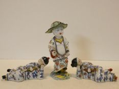 An antique hand painted Oriental figure with leaf hat and in traditional robe, intricately decorated