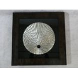 A contemporary carved wood textured silver disk, mounted on black, shadow box framed. 80x80cm