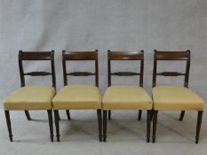 A set of four late Georgian mahogany bar back dining chairs with ebony Greek key pattern inlay above