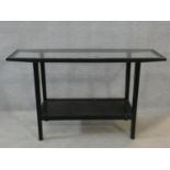 A tubular metal framed console table with inset plate glass top and fitted with undertier. H.75xW.
