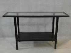 A tubular metal framed console table with inset plate glass top and fitted with undertier. H.75xW.