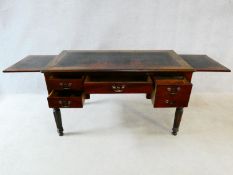 An early 19th century mahogany writing table with tooled leather inset top and two pull out slides