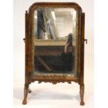 An Georgian walnut and gilt swing mirror with shaped bevelled plate. 52x33cm