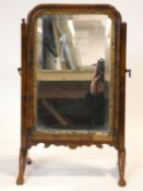 An Georgian walnut and gilt swing mirror with shaped bevelled plate. 52x33cm