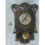 An Art Nouveau carved oak Iris flower motif wall clock with stylised floral engraved copper pendulum