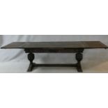 A Carolean style oak refectory dining table with end draw leaf extensions on heavy carved baluster