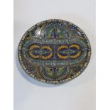 A large glazed and hand painted ceramic Moroccan charger with stylised floral design in blues,