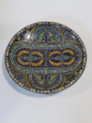 A large glazed and hand painted ceramic Moroccan charger with stylised floral design in blues,