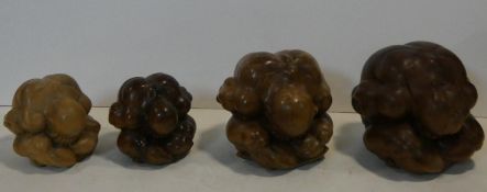 A collection of four carved Eastern figures, Orang Malu, the weeping Buddha, head in hands curled