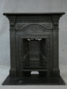 An ornately cast 19th century iron fire surround, mantel shelf and insert with grate on marble