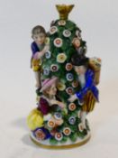 A Chelsea style porcelain perfume bottle with three figures around a spire of flowers and foliage