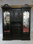 A late 19th century carved mahogany three section compactum wardrobe fitted with central drawers