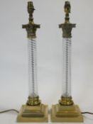 A pair of antique brass table lamp bases with Corinthian style capitals on glass twist columns on