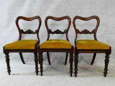 A set of three Victorian mahogany shaped back dining chairs with drop in seats on turned tapering