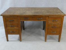 A mid century oak pedestal desk on square tapering supports. H.77 W.153 D.78cm