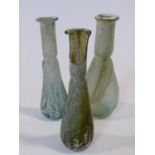 Three pale green and blue blown glass phials, possibly Roman. H.12cm