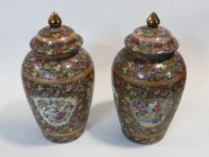 A pair of Chinese Famille Rose porcelain lidded temple jars, panels with village scenes. Qianlong