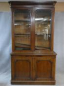 A Victorian mahogany library bookcase with upper glazed doors enclosing book shelves above base
