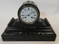 An early 19th century marble and slate mantel clock with Roman numerals on a white enamel dial. H.