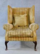 A Georgian style wing back armchair in ribbed velour upholstery on cabriole supports. H.110xW.85xD.