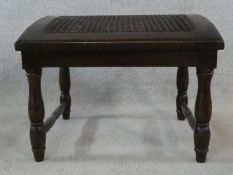 An oak country style footstool with caned and sloping top. H.39 W.51 D.46cm