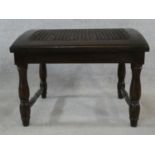 An oak country style footstool with caned and sloping top. H.39 W.51 D.46cm