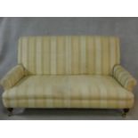 A Victorian style sofa in striped and floral patterned upholstery on turned tapering supports