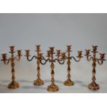 A collection of five copper effect metal three branch table candelabras. H.40cm
