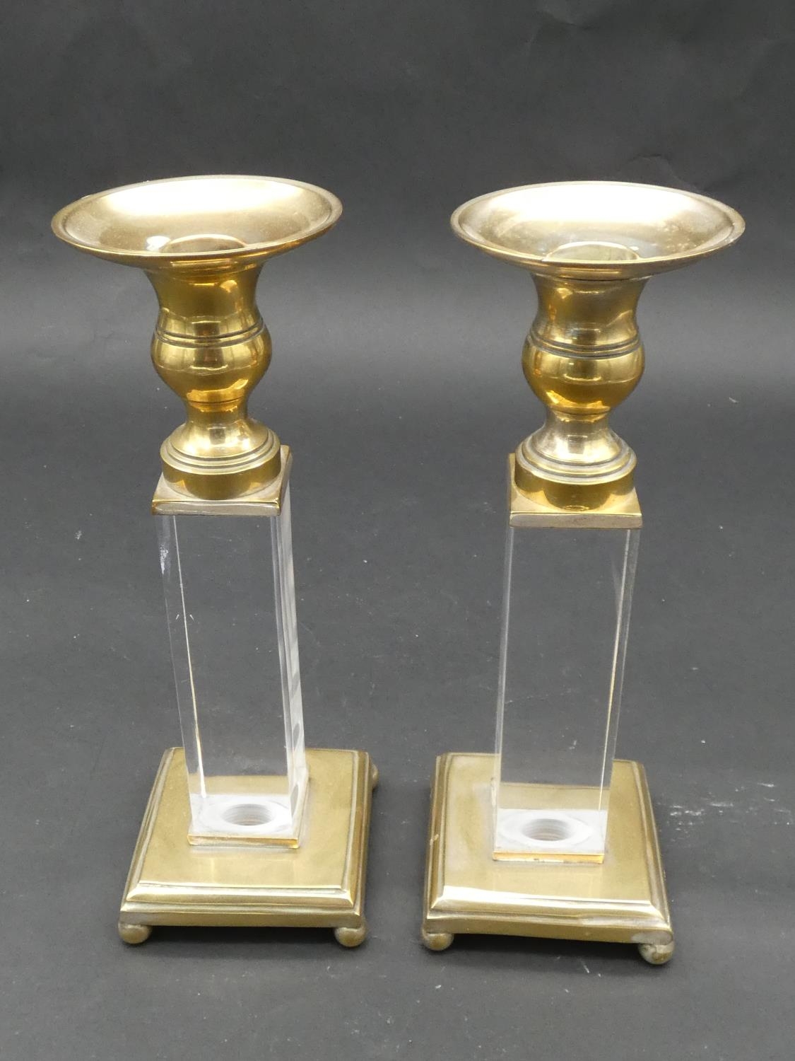 A pair of brass and perspex Empire style candlesticks on platform bases resting on ball feet. H.25cm