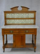 A 19th century satin walnut marble topped washstand with Art Nouveau tiled upstand, fitted with