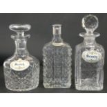 Three cut crystal drinks decanters, two with stoppers and one with a silver plated top, each with