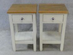 A pair of painted bedside tables fitted with frieze drawers on square supports united by