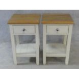 A pair of painted bedside tables fitted with frieze drawers on square supports united by