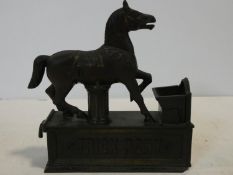 A vintage 'Trick Pony' cold painted cast iron novelty moving money box in the form of a horse