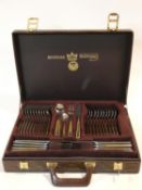 A brown faux leather cased complete Bestecke SBS Solingen canteen of cutlery, in 23/24ct gold