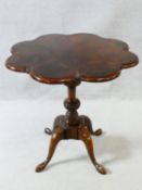 A Georgian style flame mahogany segment veneered shaped top occasional table on central turned